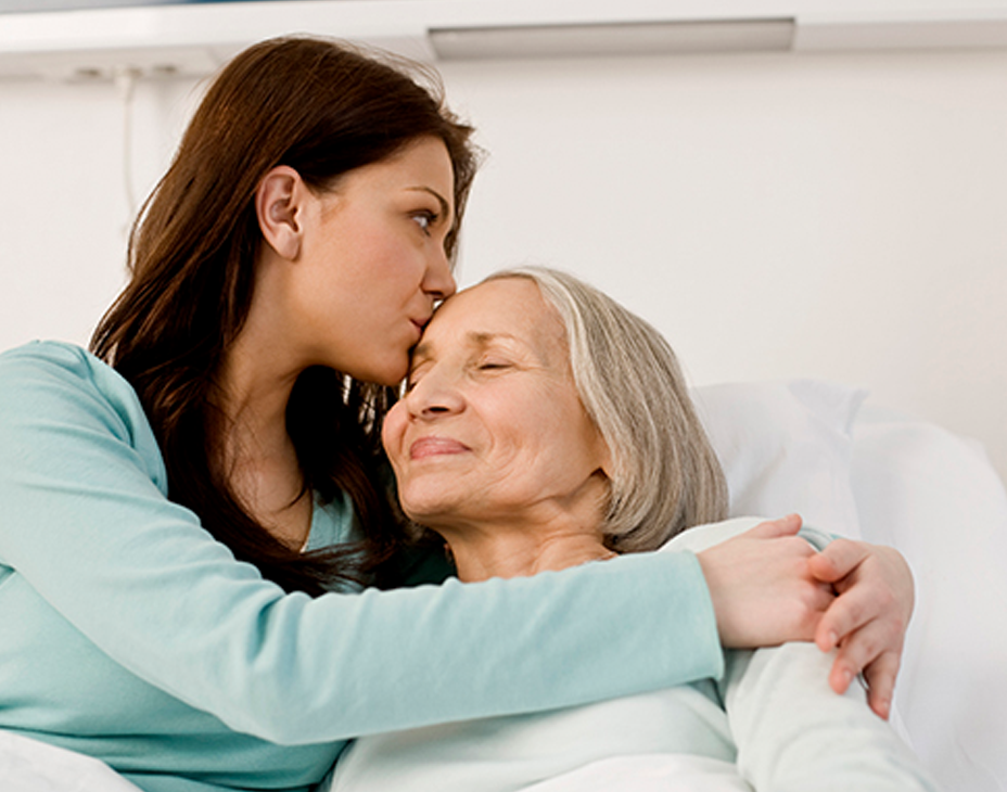 Stock image of adult woman hugging her senior mother