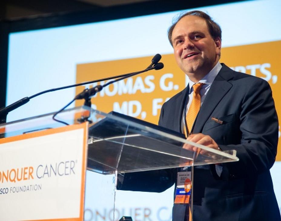 Dr. Thomas Roberts speaking at a podium at the 2019 ASCO Annual Meeting.