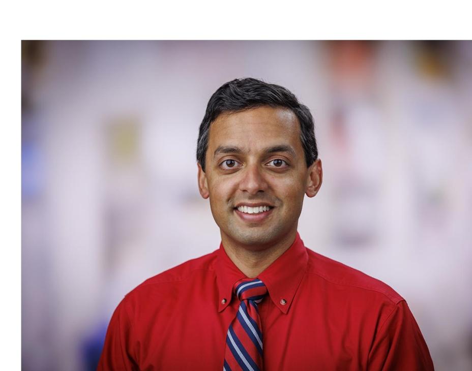 Headshot of Dr. Rahul Banerjee in a clinical setting. He is smiling facing forward