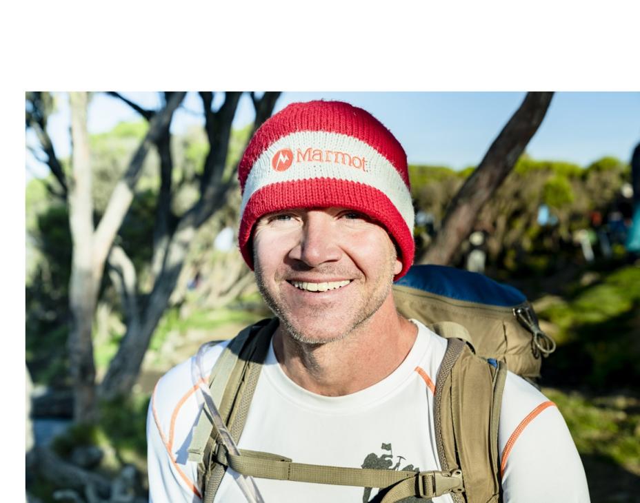 Sean Swarner in an outdoor setting wearing a climber backpack, smiling facing forward