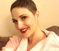 Melissa Berry during cancer treatment. She has shorter hair and is taking a selfie while smiling.