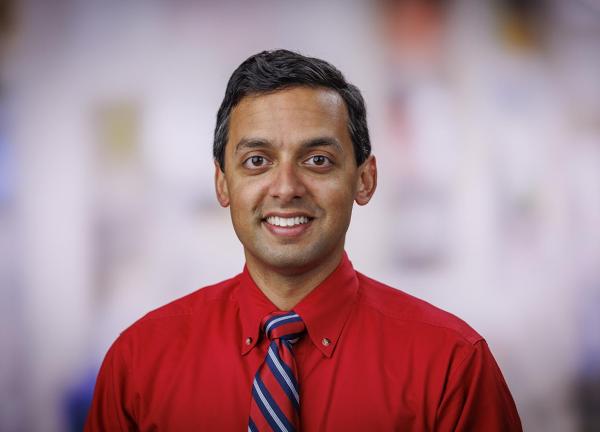 Headshot of Dr. Rahul Banerjee in a clinical setting. He is smiling facing forward