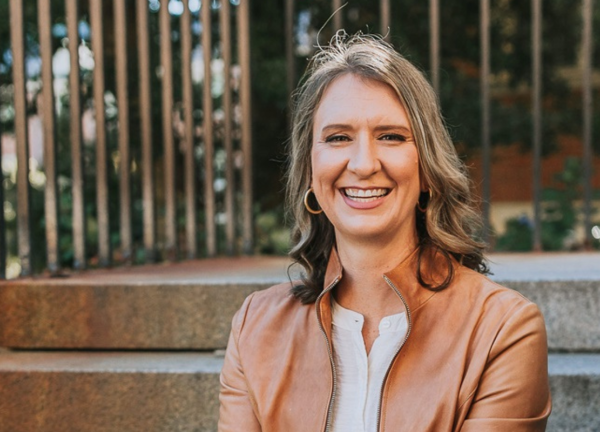 Dr. Stacy Wentworth sitting outdoors on steps, smiling facing forward.