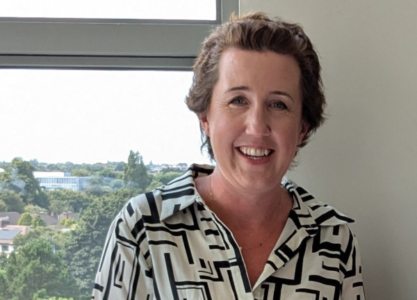 Aisling O'Brien smiling facing forward near a window