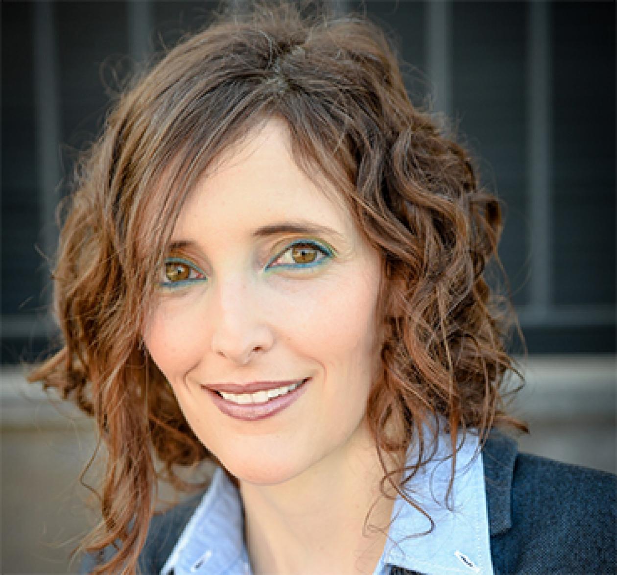 A headshot of Dr. Shlomit Strulov Shachar smiling facing forward, wearing a blue collared shirt.