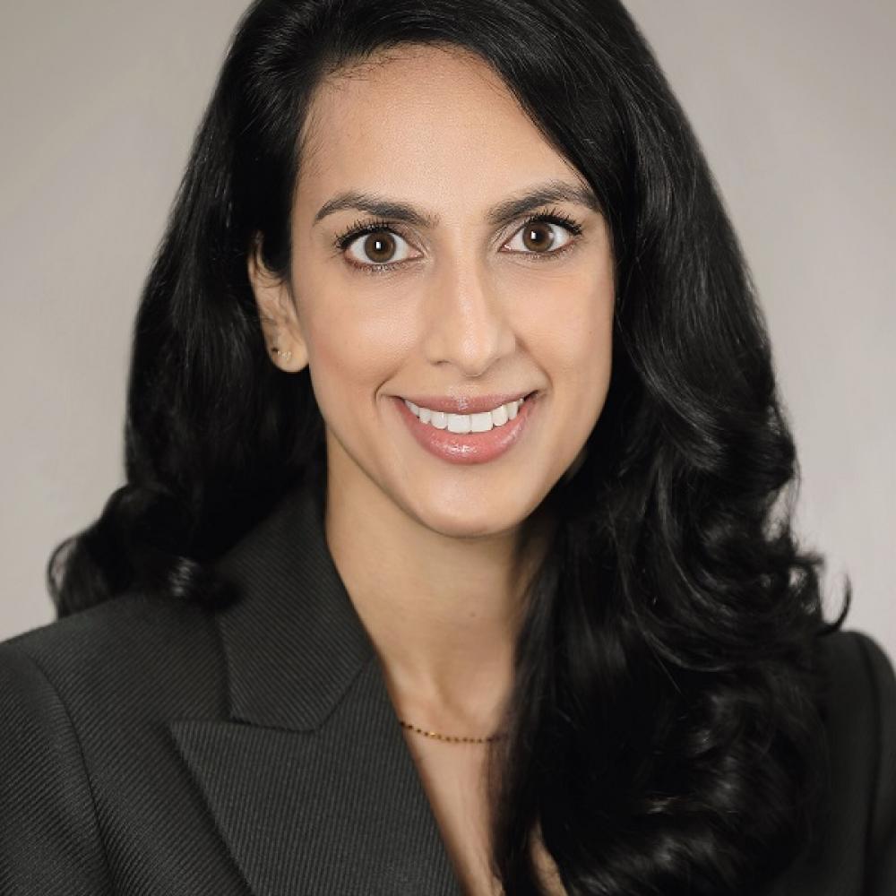 Dr. Lekha Mikkilineni smiling facing forward; headshot from chest up. She is wearing a black blazer and has long black hair.