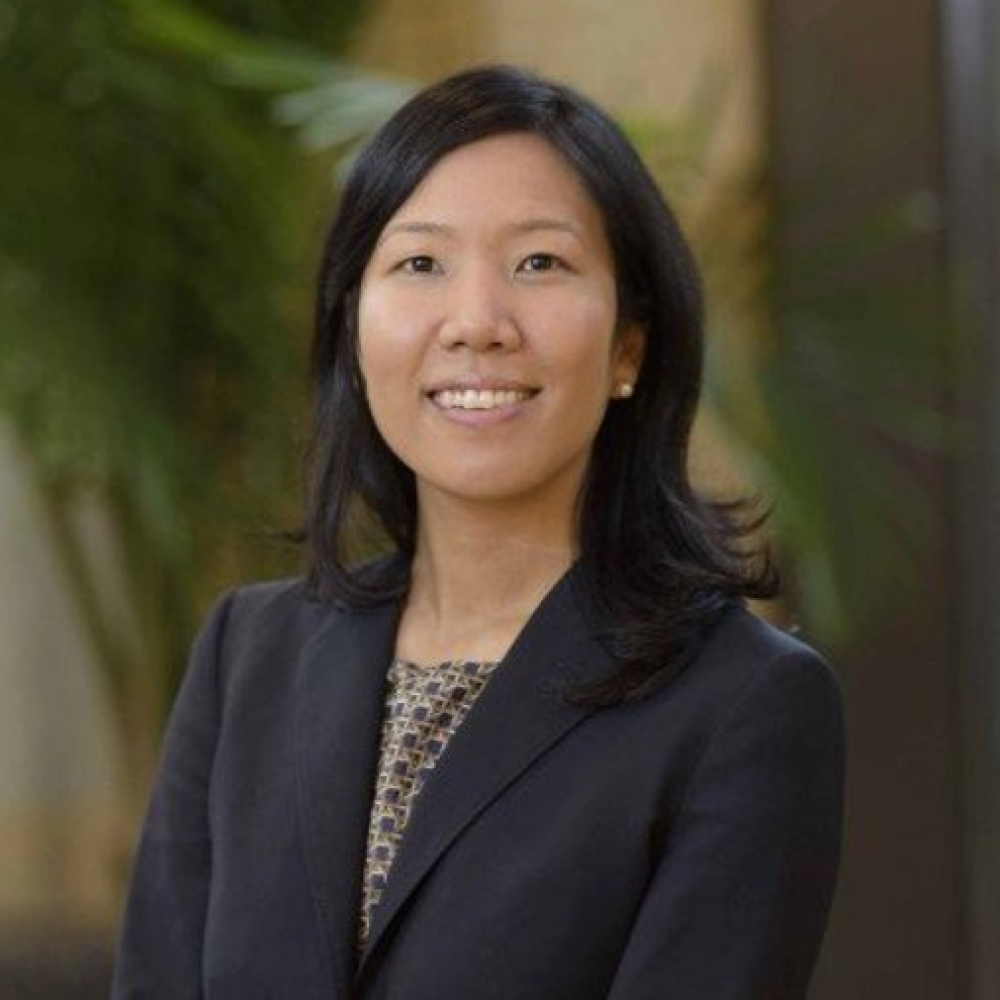 Headshot of Dr. Chrisann Kyi. She is smiling facing forward and wearing a black blazer and has shoulder-length black hair.