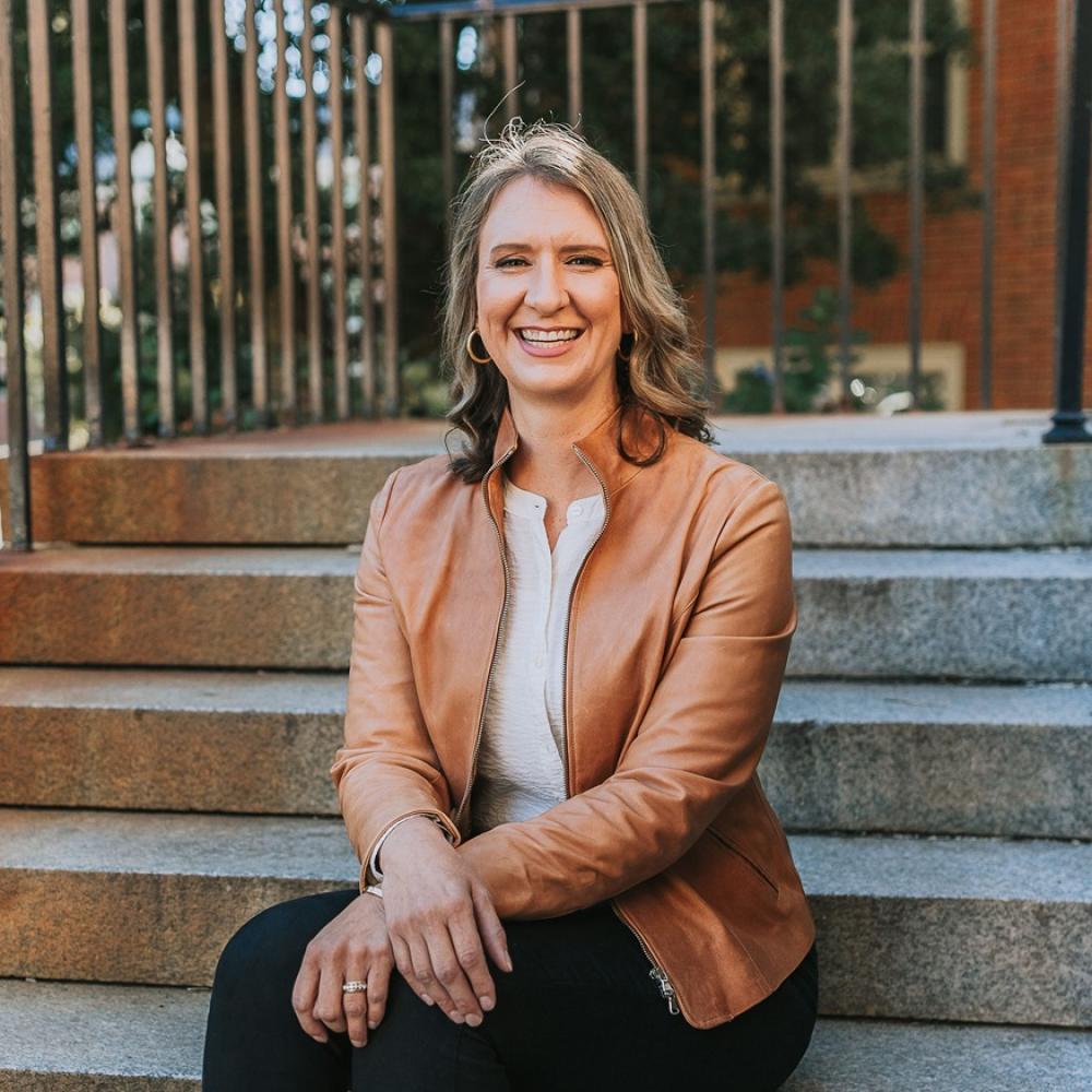 Dr. Stacy Wentworth sitting outdoors on steps, smiling facing forward.